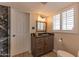 Updated bathroom features wood-look floors, granite countertop, framed mirror, and white door at 6702 E Monte Vista Rd, Scottsdale, AZ 85257