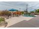 Fenced pool area has a large concrete deck, mature landscaping, and shade umbrella at 6702 E Monte Vista Rd, Scottsdale, AZ 85257