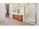 Bathroom with a wood vanity, large mirror, and glass shower at 6915 S Sapphire Way, Chandler, AZ 85249