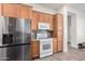 Well-lit kitchen features stainless steel refrigerator, white stove, microwave, and wooden cabinets at 6915 S Sapphire Way, Chandler, AZ 85249