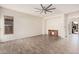 Spacious living room with wood-look tile flooring, natural light, and a rustic entertainment center at 6915 S Sapphire Way, Chandler, AZ 85249