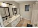 Modern bathroom with dual sinks, mirrors, and a combined shower and tub at 8227 N 47Th Dr, Glendale, AZ 85302