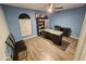 Bedroom featuring blue walls, an arched window and laminate wood flooring at 8227 N 47Th Dr, Glendale, AZ 85302