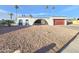 Single-story home featuring a desert landscaped front yard, red garage door and architectural charm at 8227 N 47Th Dr, Glendale, AZ 85302