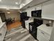 Modern kitchen featuring white cabinets, black appliances, gray backsplash, and laminate flooring at 8227 N 47Th Dr, Glendale, AZ 85302