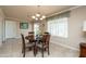 Cozy dining area featuring a chandelier, a window, and a sliding door for outdoor access at 9634 W Glen Oaks N Cir, Sun City, AZ 85351