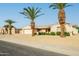 Desirable single-story home featuring a two-car garage, desert landscaping and mature palm trees at 9634 W Glen Oaks N Cir, Sun City, AZ 85351