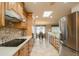 Spacious kitchen offering stainless steel appliances, tile backsplash and countertops, and a skylight at 9634 W Glen Oaks N Cir, Sun City, AZ 85351