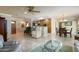 Spacious living room with tile floors, a ceiling fan, and an arched entry to the kitchen at 9634 W Glen Oaks N Cir, Sun City, AZ 85351