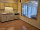 Kitchen with stainless steel sink, light cabinets, and view of the sunroom at 9847 W Silver Bell Dr, Sun City, AZ 85351