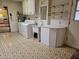 Functional laundry room with appliances and a sink, complemented by unique patterned flooring at 9847 W Silver Bell Dr, Sun City, AZ 85351