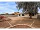 View of the backyard that features a large tree and red brick accents throughout the landscape at 10135 W Orange Dr, Glendale, AZ 85307