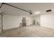 Spacious garage with a concrete floor, side door, and an automatic door opening system at 10135 W Orange Dr, Glendale, AZ 85307