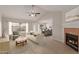 Inviting living room featuring a fireplace, ceiling fan, and a seamless flow to the dining area at 10135 W Orange Dr, Glendale, AZ 85307