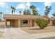 Single-story home features a covered carport and mature desert landscaping at 10848 W Crosby Dr, Sun City, AZ 85351