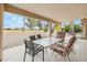 Covered patio with tiled flooring, comfortable seating arrangement, and serene views of the well-manicured backyard at 10848 W Crosby Dr, Sun City, AZ 85351