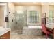 Elegant bathroom featuring a glass shower, soaking tub, and vanity area with neutral tilework at 11133 N 120Th Pl, Scottsdale, AZ 85259