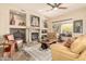 Inviting living room features a stone fireplace, neutral paint, ceiling fan, and abundant natural light at 11133 N 120Th Pl, Scottsdale, AZ 85259