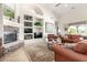 Cozy living room with built-in bookshelves, fireplace, plush seating, and access to the patio at 12113 E Laurel Ln, Scottsdale, AZ 85259