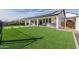 Spacious backyard with artificial grass, a covered patio, and solar panels on the roof at 1265 E La Fortuna Ct, San Tan Valley, AZ 85140