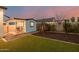 A backyard with synthetic grass, play structure, shed, and dining table at 1265 E La Fortuna Ct, San Tan Valley, AZ 85140
