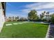 Backyard with artificial turf and concrete pavers lead to a pool with lounge chairs at 1265 E La Fortuna Ct, San Tan Valley, AZ 85140