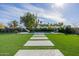 Backyard pool area with artificial turf, concrete pavers, slide, and lounge chairs at 1265 E La Fortuna Ct, San Tan Valley, AZ 85140