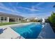 Backyard pool with a slide and pavers, surrounded by artificial turf and a black fence at 1265 E La Fortuna Ct, San Tan Valley, AZ 85140