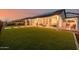 Large backyard with lush green grass, a covered patio, and solar panels on the roof at 1265 E La Fortuna Ct, San Tan Valley, AZ 85140