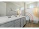 Well-lit bathroom with a double sink vanity, large mirror, and stylish rainbow shower curtain at 1265 E La Fortuna Ct, San Tan Valley, AZ 85140