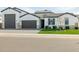 Gorgeous single-story home with a brick driveway, well-manicured lawn and white color scheme at 1265 E La Fortuna Ct, San Tan Valley, AZ 85140
