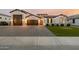 Beautiful single-story home featuring a three-car garage, manicured lawn, and modern architectural details at 1265 E La Fortuna Ct, San Tan Valley, AZ 85140