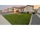 Inviting front yard with lush artificial grass, a young tree, and a modern home exterior at 1265 E La Fortuna Ct, San Tan Valley, AZ 85140