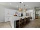 Well-lit kitchen with a spacious island, seating, white cabinetry, stainless steel appliances, and modern design elements at 1265 E La Fortuna Ct, San Tan Valley, AZ 85140