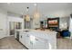 Open kitchen with a large island, white cabinets, and stainless steel appliances, flowing into the living area at 1265 E La Fortuna Ct, San Tan Valley, AZ 85140