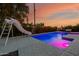 Backyard swimming pool with a slide and sleek lounge area surrounded by desert landscape at 1265 E La Fortuna Ct, San Tan Valley, AZ 85140