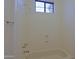 Bathtub and shower combination with light color and natural light through a window at 130 E Jordon Ln, Phoenix, AZ 85086