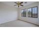 Bedroom featuring carpet floors, ceiling fan, and two windows providing outdoor views at 130 E Jordon Ln, Phoenix, AZ 85086