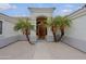 Inviting front entrance with palm trees, stone pathway, and an arched entryway at 130 E Jordon Ln, Phoenix, AZ 85086