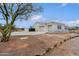 Attached two-car garage with white doors, complemented by desert landscaping and a tree at 130 E Jordon Ln, Phoenix, AZ 85086