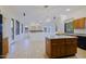 Spacious kitchen with an island, tile floors, and ample counter space, blending seamlessly into the living area at 130 E Jordon Ln, Phoenix, AZ 85086