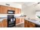 Traditional kitchen features wood cabinetry, black appliances, and ample counter space at 1417 N Brittany Ln, Gilbert, AZ 85233