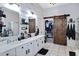 Main bathroom with dual sinks, sliding barn door, and walk-in closet at 1554 E Stirrup Ct, Gilbert, AZ 85296