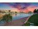 Lakeside view featuring lush landscaping and waterfront homes with beautiful sunset sky at 16013 S Desert Foothills Pkwy # 2089, Phoenix, AZ 85048