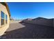 Gravel backyard, bordered by a cinder block wall, offering privacy and low maintenance at 16071 W Sand Hills Rd, Surprise, AZ 85387