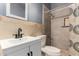 Comfortable bathroom with a light-patterned tile wall and a sink and toilet with shower to the right at 1635 W Dunbar Dr, Phoenix, AZ 85041