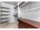 Walk-in closet features multiple shelves and storage options with carpet flooring and gray painted walls at 1635 W Dunbar Dr, Phoenix, AZ 85041