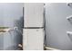 Laundry room featuring a stacked washer and dryer set, with shelves on the wall at 1635 W Dunbar Dr, Phoenix, AZ 85041