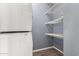Laundry room showcasing a stacked washer and dryer set, with shelves on the wall at 1635 W Dunbar Dr, Phoenix, AZ 85041