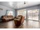 Open living room area with laminate floors, ceiling fans, and large windows for natural light at 1635 W Dunbar Dr, Phoenix, AZ 85041